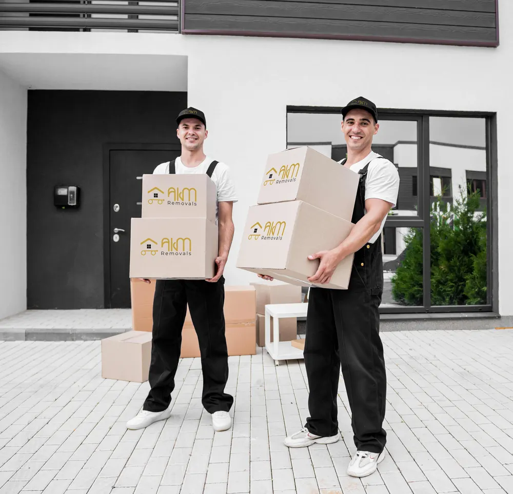AKM Removals team carrying branded boxes